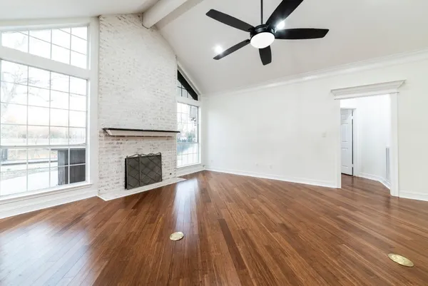 a view of empty room with wooden floor and fireplace