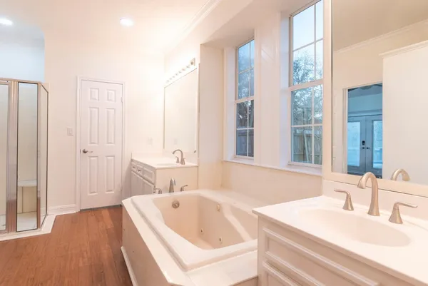 a bathroom with a tub sink and mirror
