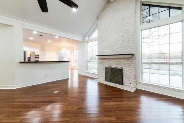 wooden floor fireplace and windows in an empty room