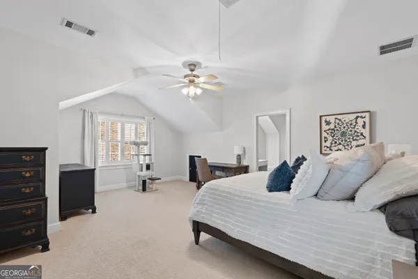 a bedroom with a bed and painting on the wall