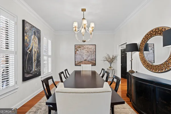 a view of a dining room with furniture a chandelier and a window