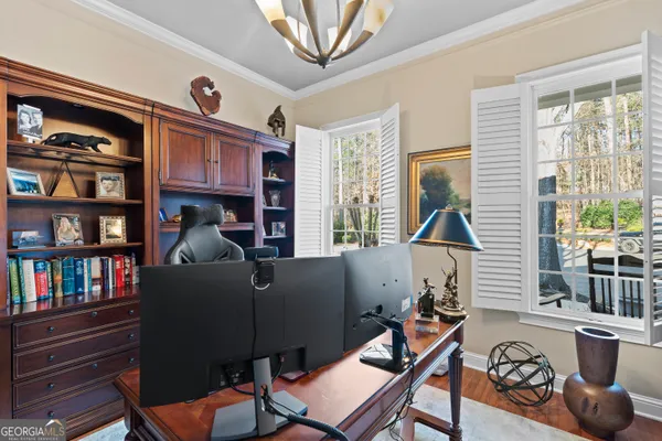 a living room with furniture a bookshelf and a window