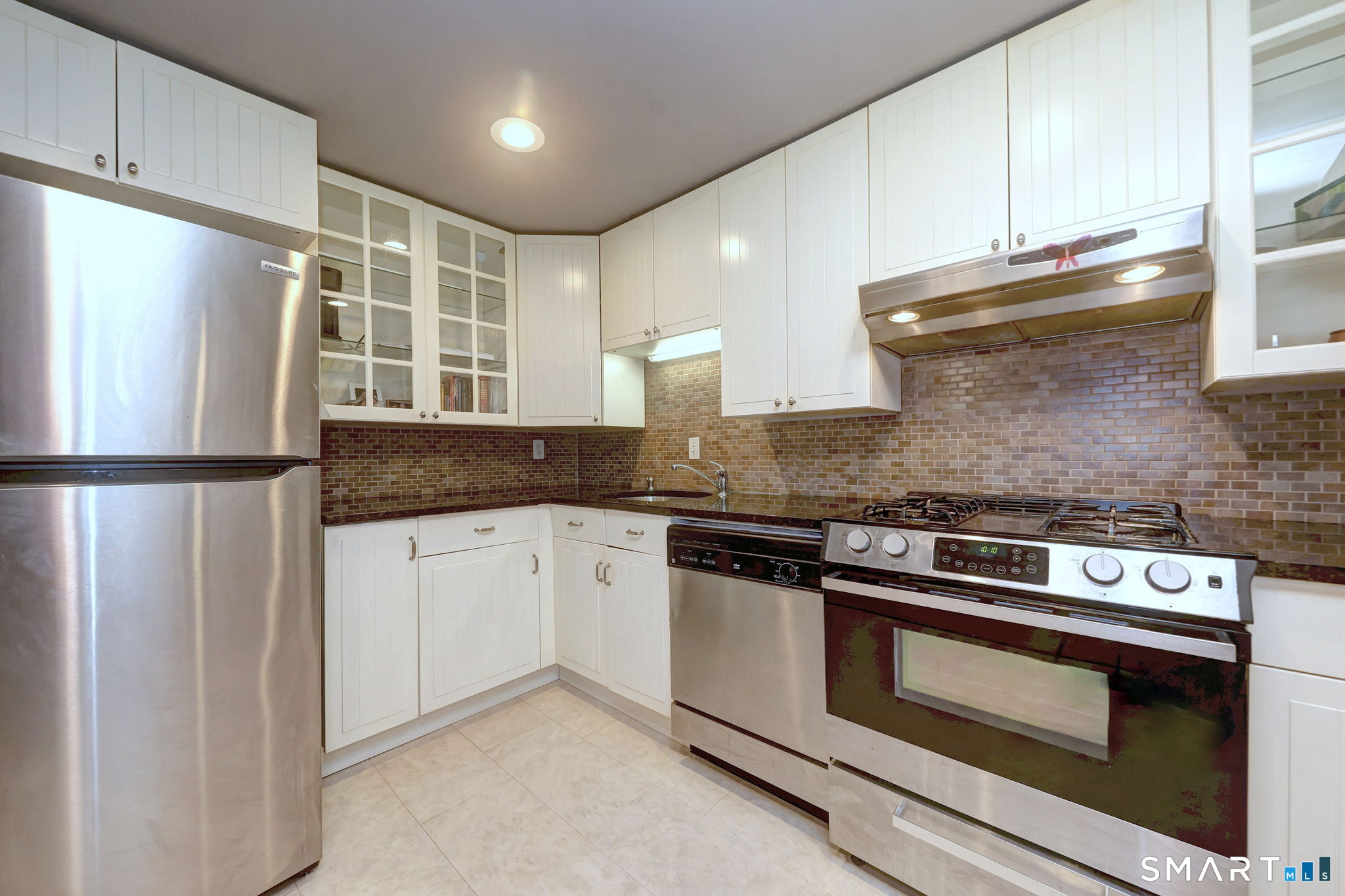 55 Dowd Avenue, Unit 22 Canton, CT 06019 - Photo 27 of 29 a kitchen with granite countertop a stove and a refrigerator