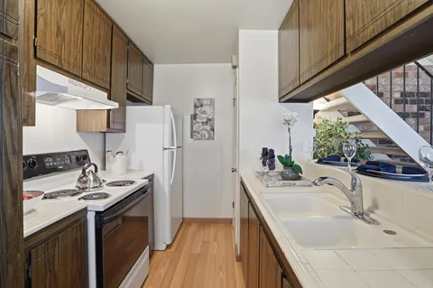 a kitchen with stainless steel appliances kitchen island granite countertop a sink stove and refrigerator