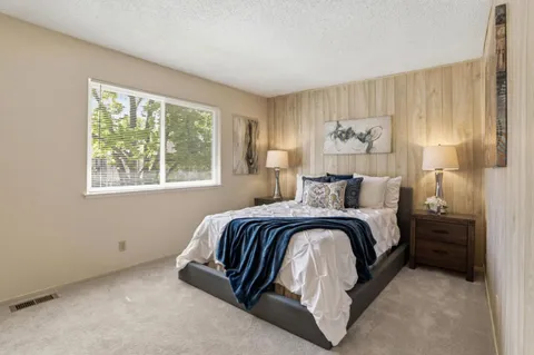 a spacious bedroom with a bed and a window