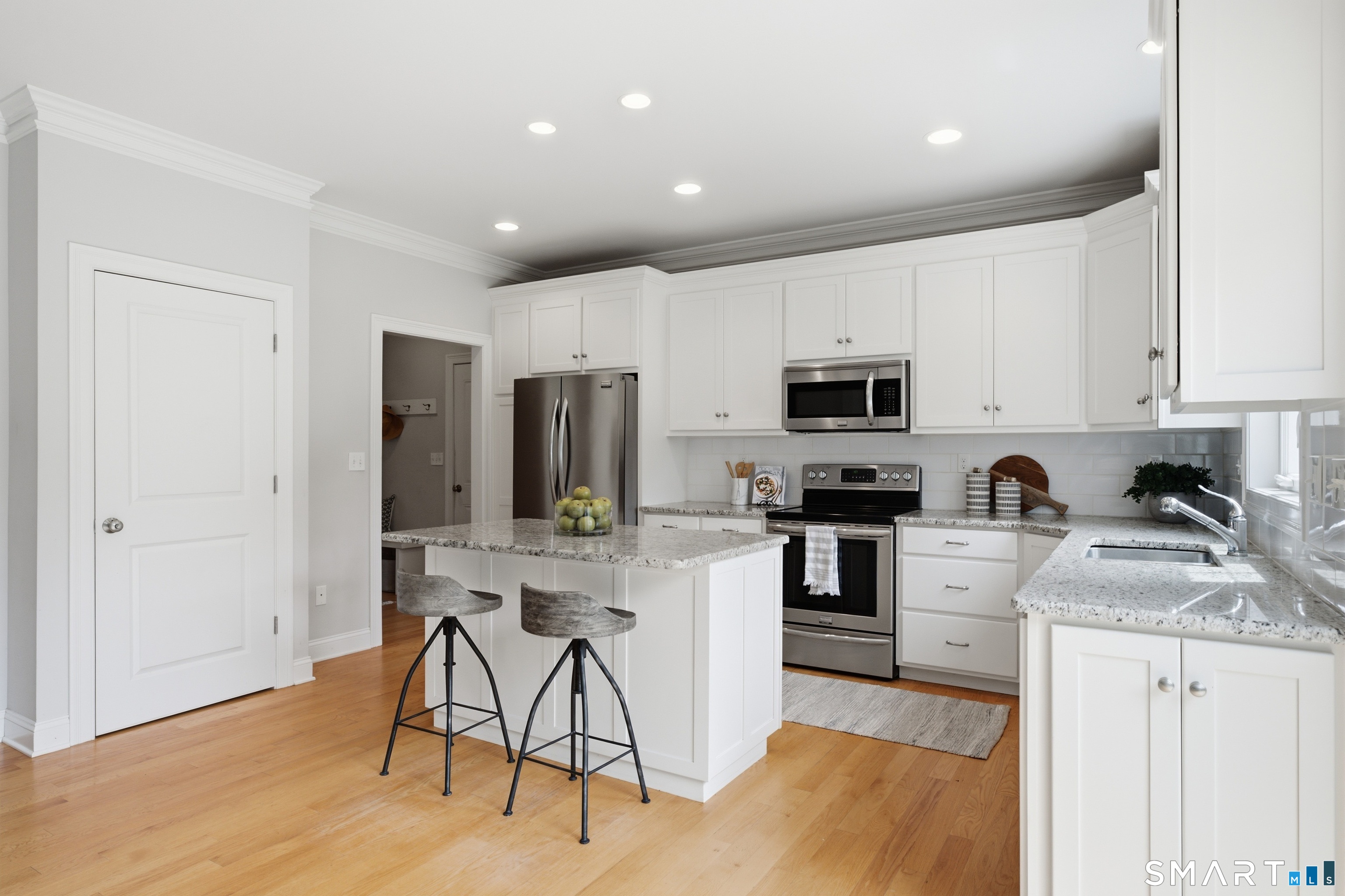 838 Little Meadow Road Guilford, CT 06437 - Photo 11 of 40 The crisp white kitchen has bar seating for 2 and a glimpse toward the mudroom, garage and the powder room