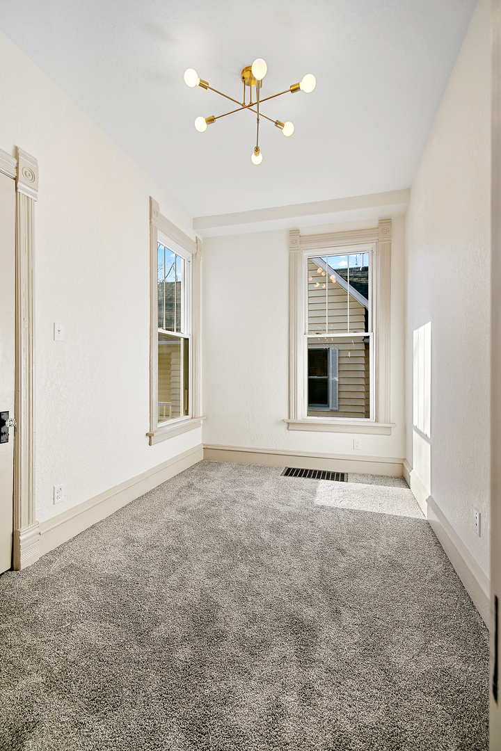 505 South Indiana Avenue Kankakee, IL 60901 - Photo 19 of 32 an empty room with chandelier fan and windows
