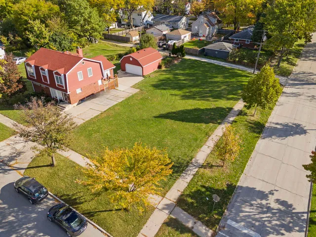 an aerial view of a house with a garden and lake view