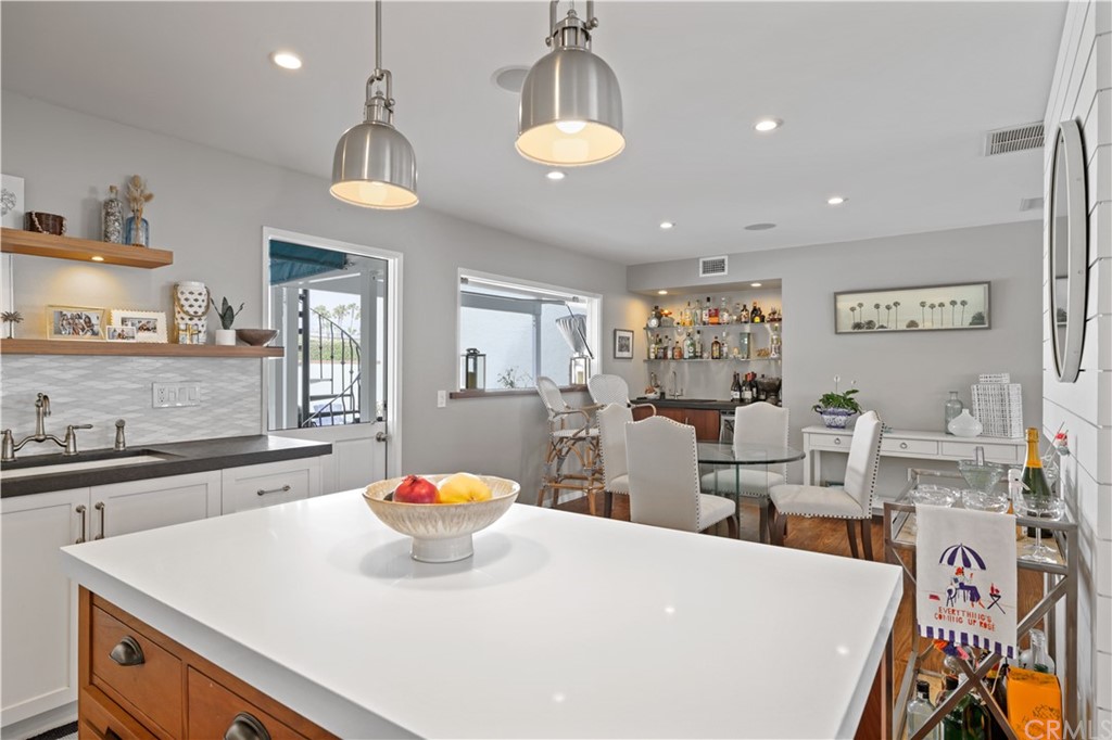 C-29 Surfside Avenue Surfside, CA 90743 - Photo 15 of 36 a kitchen with stainless steel appliances a kitchen island a stove a sink a dining table and chairs
