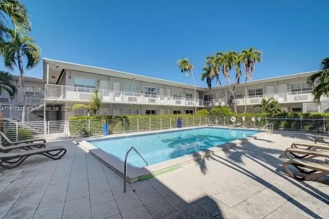 a view of a swimming pool with a lounge chairs in patio
