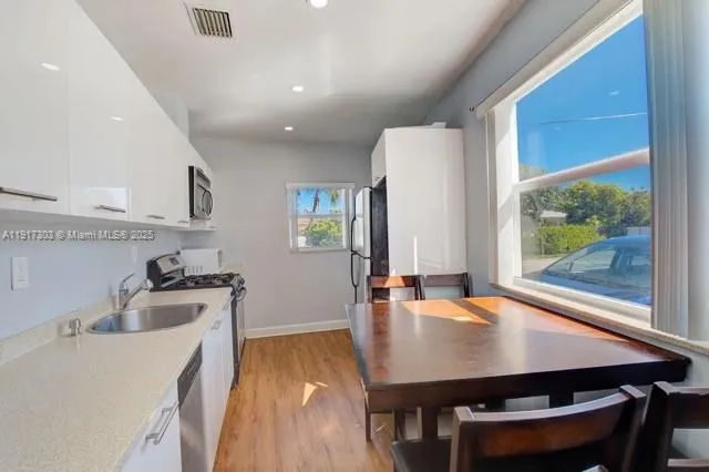 a kitchen with a table chairs sink and cabinets
