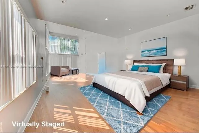 a bedroom with a large bed and a large window