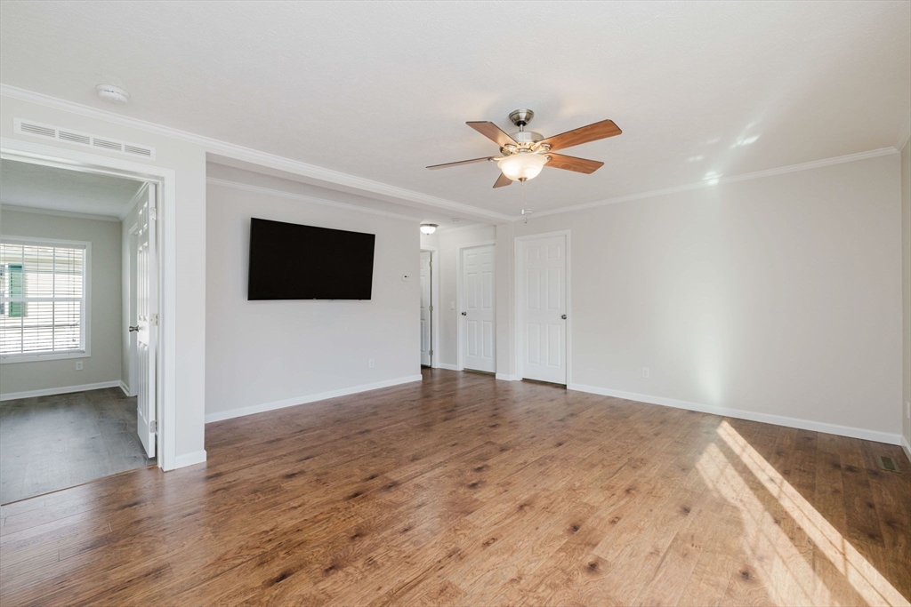 17 Maries Way Raynham, MA 02767 - Photo 18 of 39 a view of empty room with wooden floor and fan