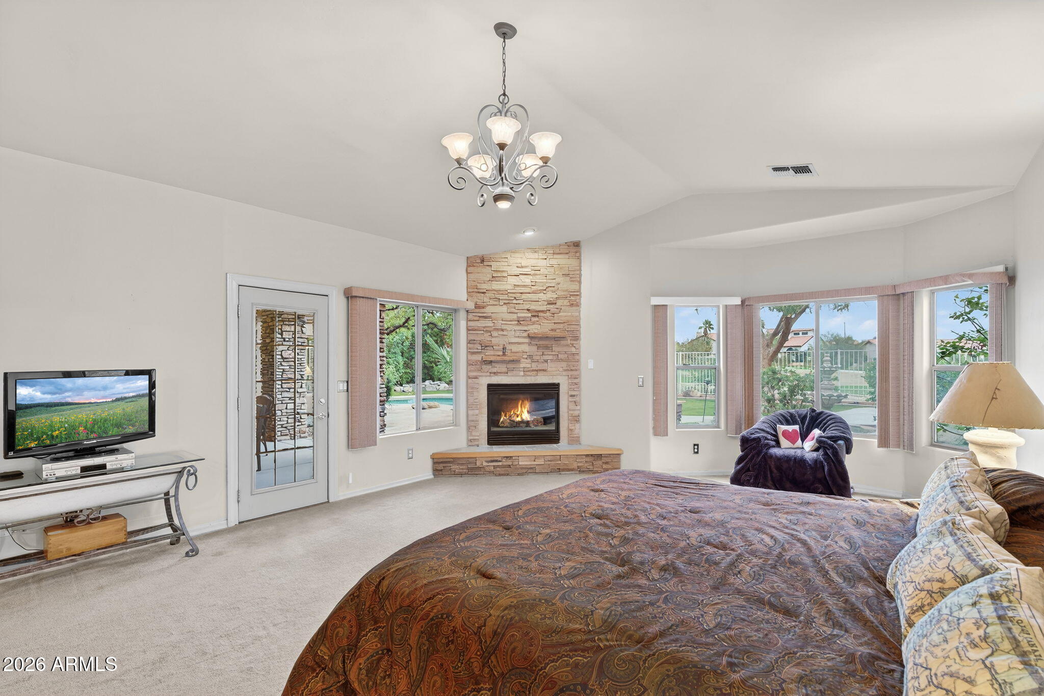 4055 North Recker Road, Unit 18 Mesa, AZ 85215 - Photo 16 of 63 a bedroom with bed and a chandelier