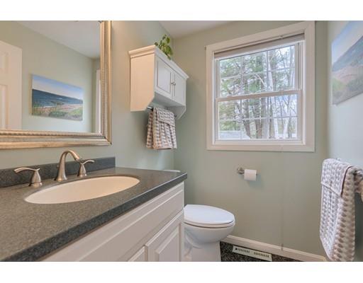 4 Garrison Road Dracut, MA 01826 - Photo 16 of 30 a bathroom with a granite countertop toilet a sink a mirror and a window