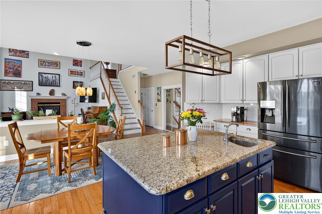 591 Rockbridge Road Nazareth, PA 18064 - Photo 13 of 73 a kitchen with granite countertop kitchen island stainless steel appliances a table chairs and a refrigerator