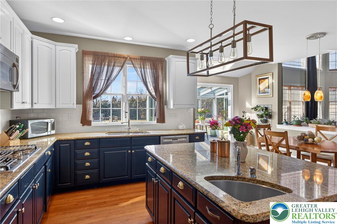 591 Rockbridge Road Nazareth, PA 18064 - Photo 9 of 73 a kitchen with stainless steel appliances granite countertop a sink a stove and a wooden cabinets