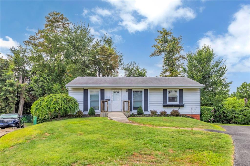 a view of a house with a yard patio and a tree