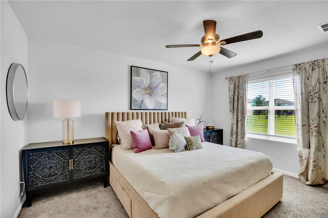 3453 Trinity Circle Fort Pierce, FL 34945 - Photo 13 of 36 a bedroom with a large bed and a window