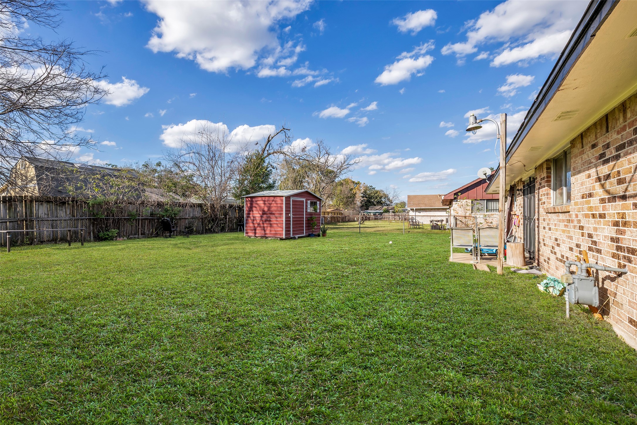 8823 Rutherford Lane Houston, TX 77088 - Photo 14 of 19 a view of a big yard with table and chairs and a fire pit
