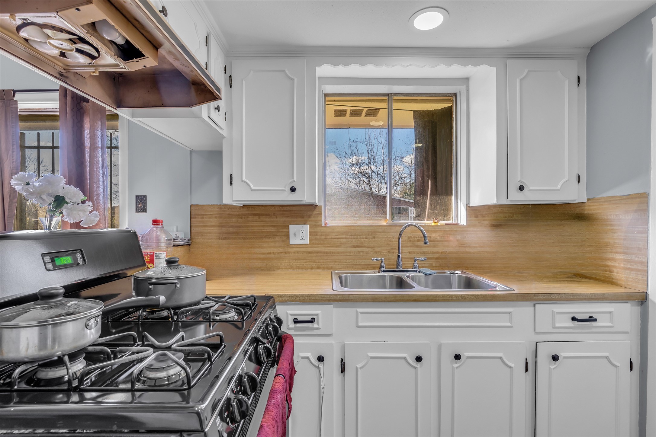 8823 Rutherford Lane Houston, TX 77088 - Photo 7 of 19 a kitchen with a sink a stove and cabinets