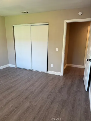an empty room with wooden floor and closet