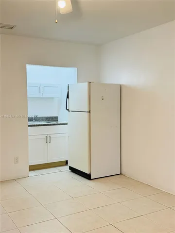a kitchen with white cabinets and white appliances