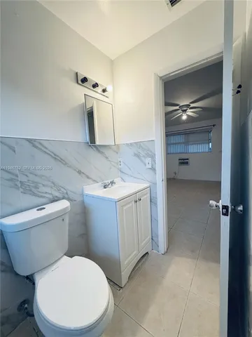 a bathroom with a granite countertop toilet and a sink
