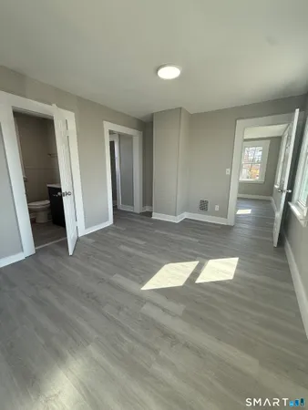 a view of empty room with wooden floor and window