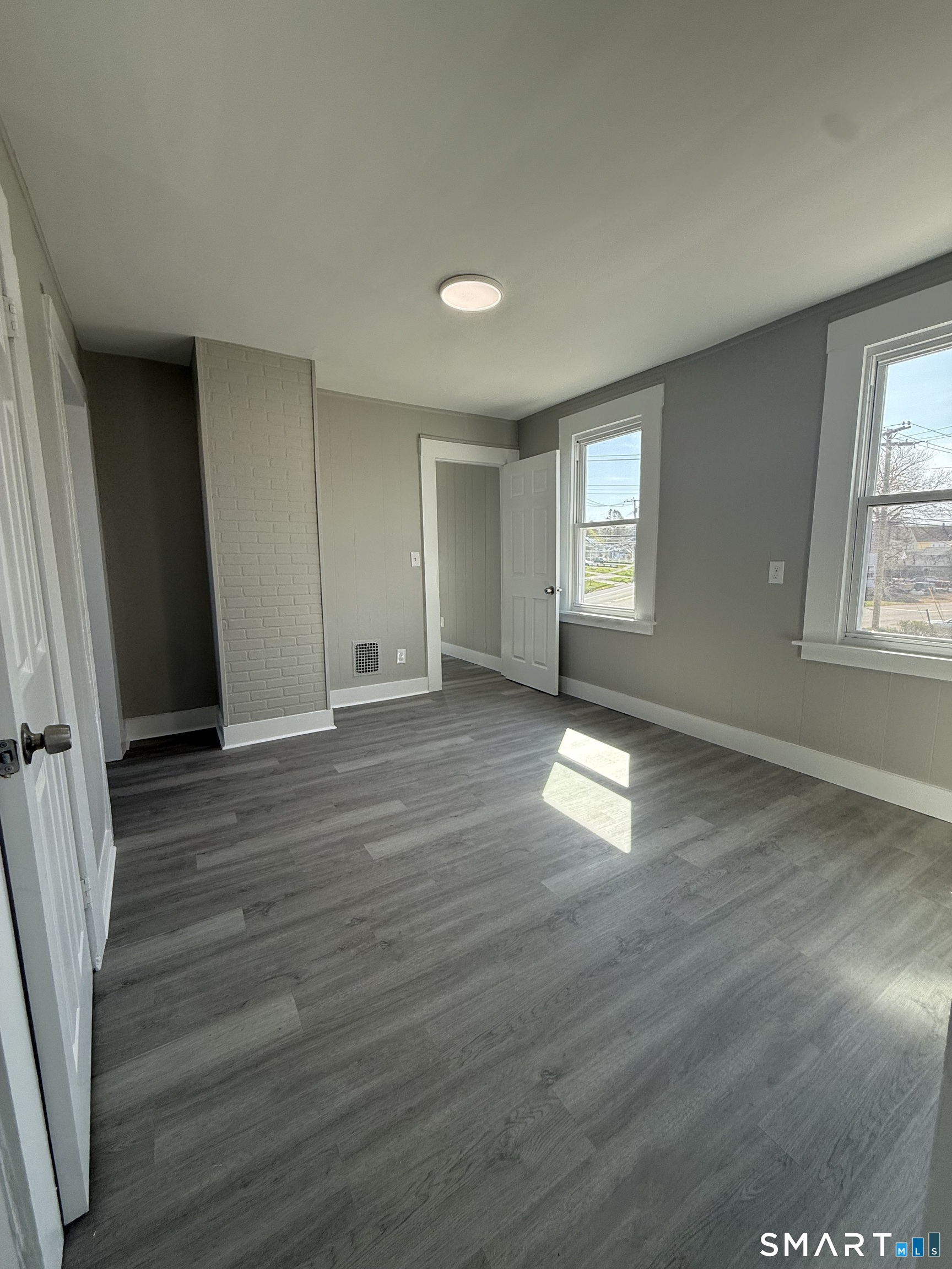 420 Short Beach Road East Haven, CT 06512 - Photo 14 of 23 an empty room with wooden floor and windows