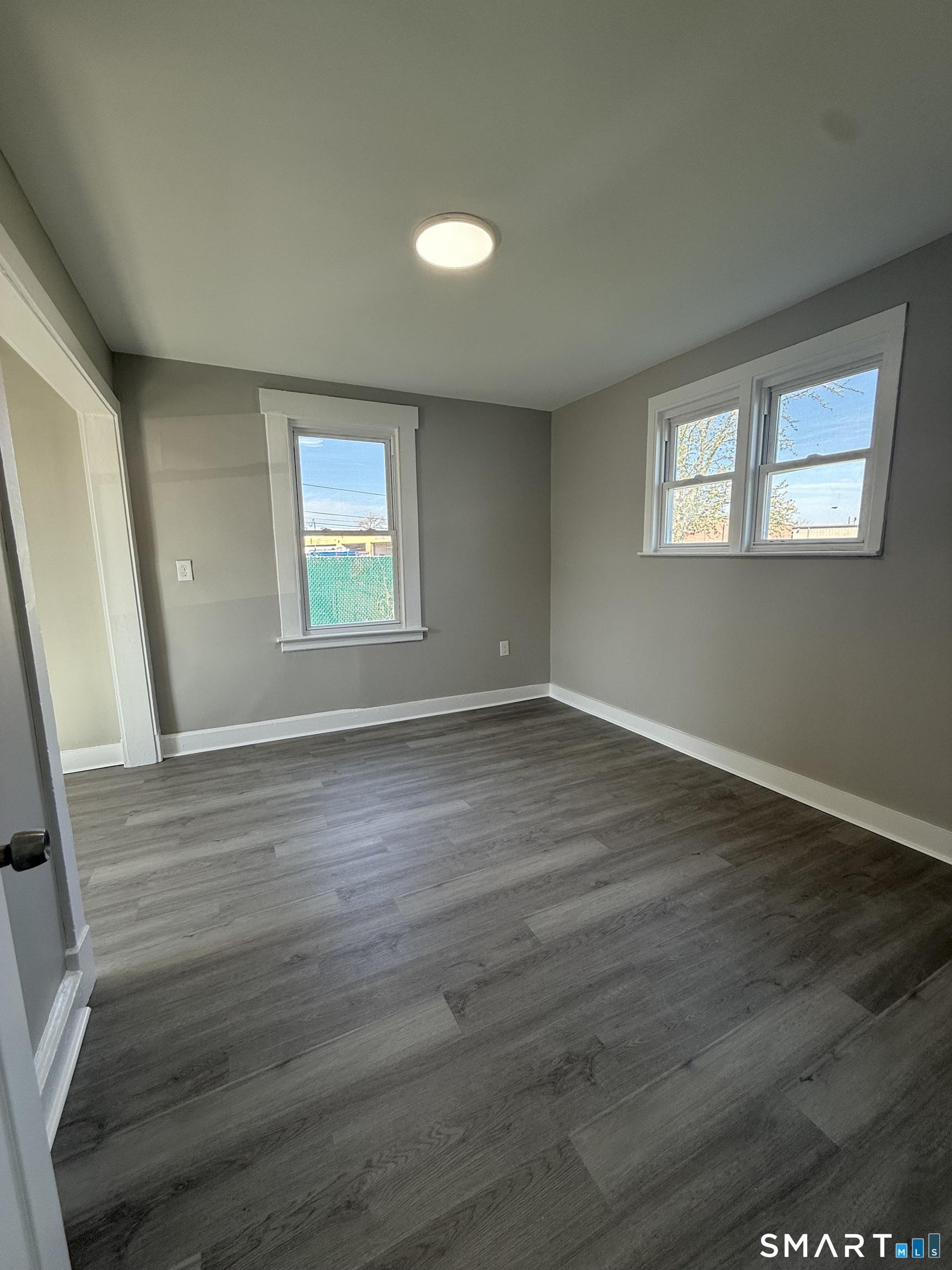 420 Short Beach Road East Haven, CT 06512 - Photo 7 of 23 an empty room with wooden floor and windows