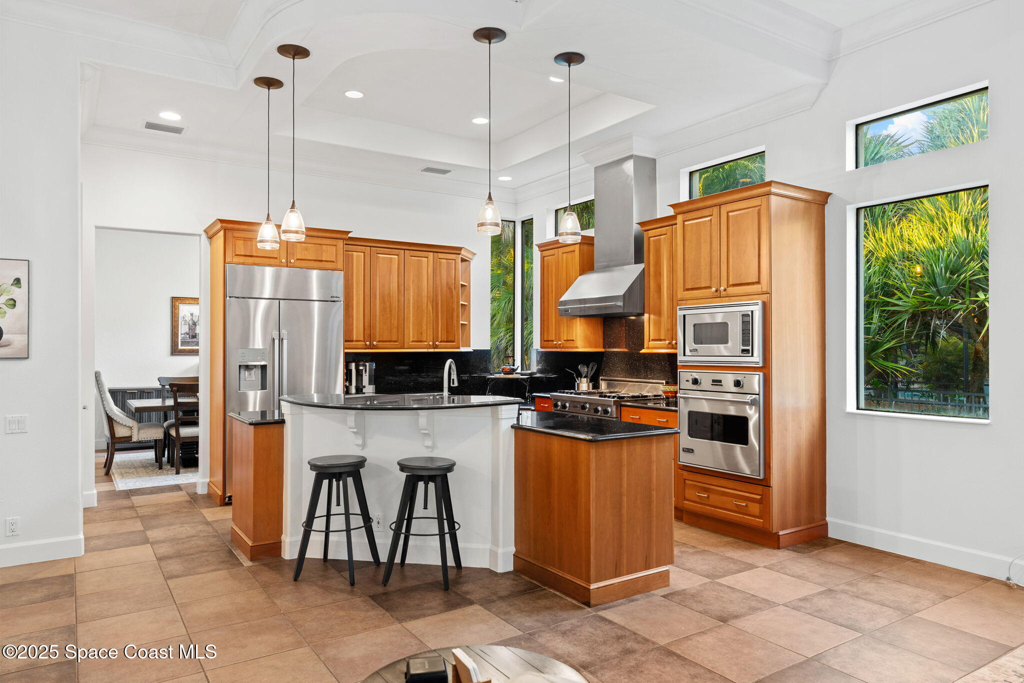 4447 Reseda Way Rockledge, FL 32955 - Photo 18 of 87 a kitchen with stainless steel appliances granite countertop a stove a refrigerator a oven a sink a dining table and chairs with wooden floor