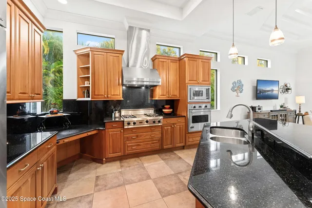a view of a hallway with entryway windows and a kitchen view