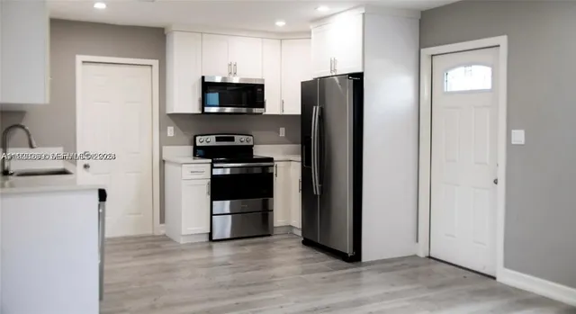 a kitchen with stainless steel appliances a refrigerator stove and microwave