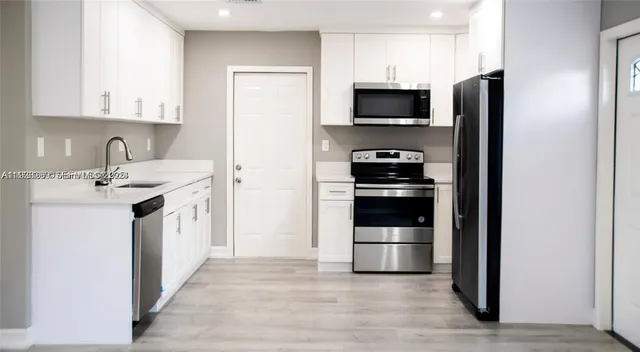 a kitchen with a sink and stainless steel appliances