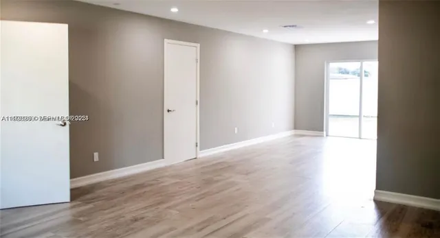 a view of an empty room with wooden floor
