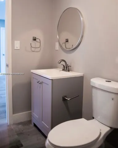 a bathroom with a toilet a sink and mirror