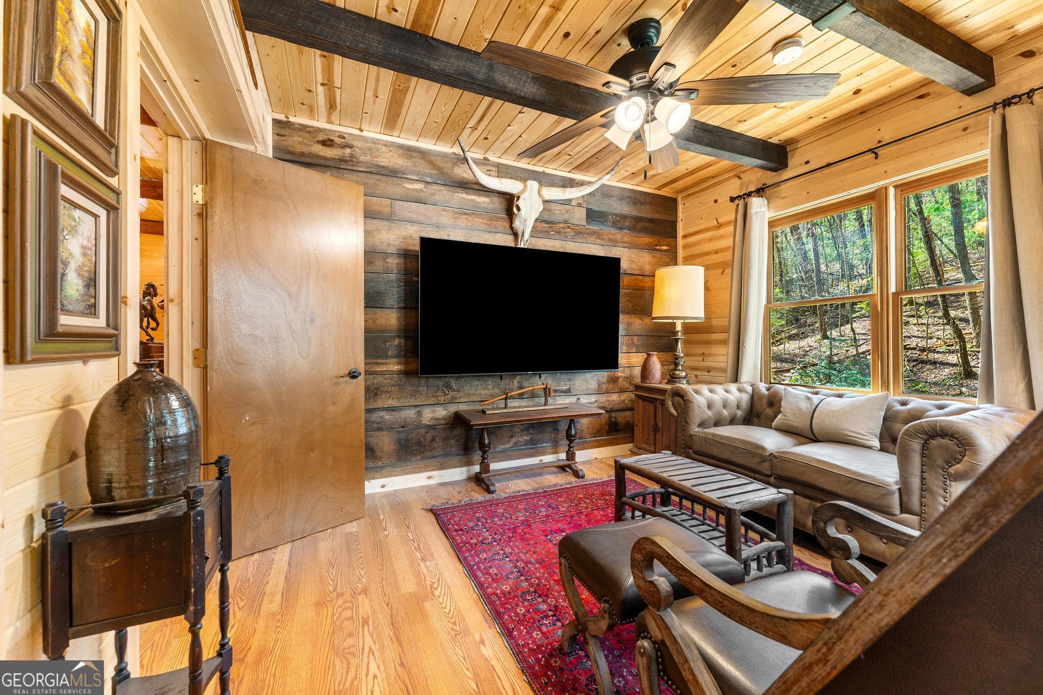 310 Blue Ridge Drive Sautee Nacoochee, GA 30571 - Photo 35 of 78 a living room with furniture a flat screen tv and a floor to ceiling window