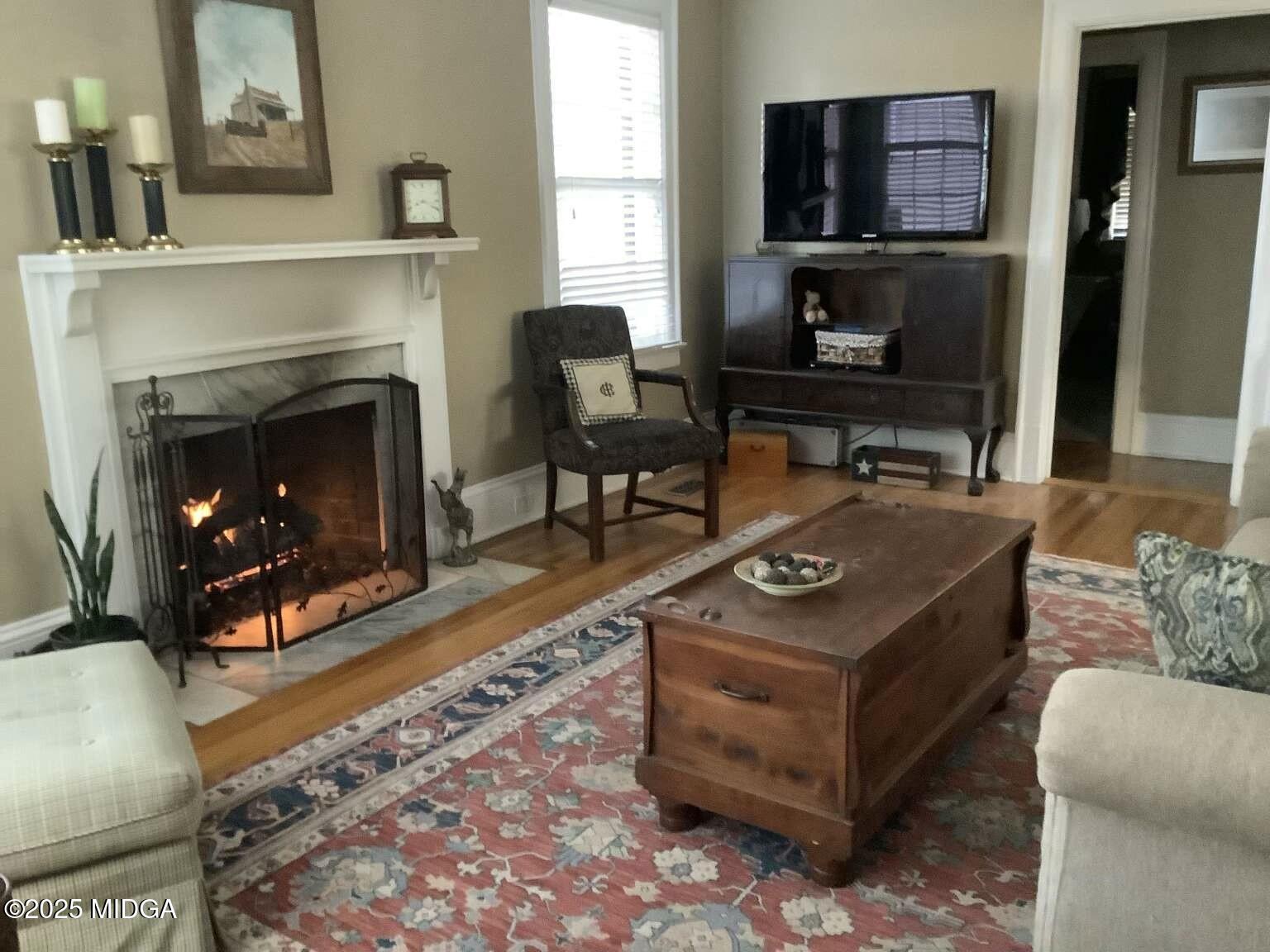 1057 Bond Street Macon, GA 31201 - Photo 17 of 27 a living room with furniture a flat screen tv and a fireplace