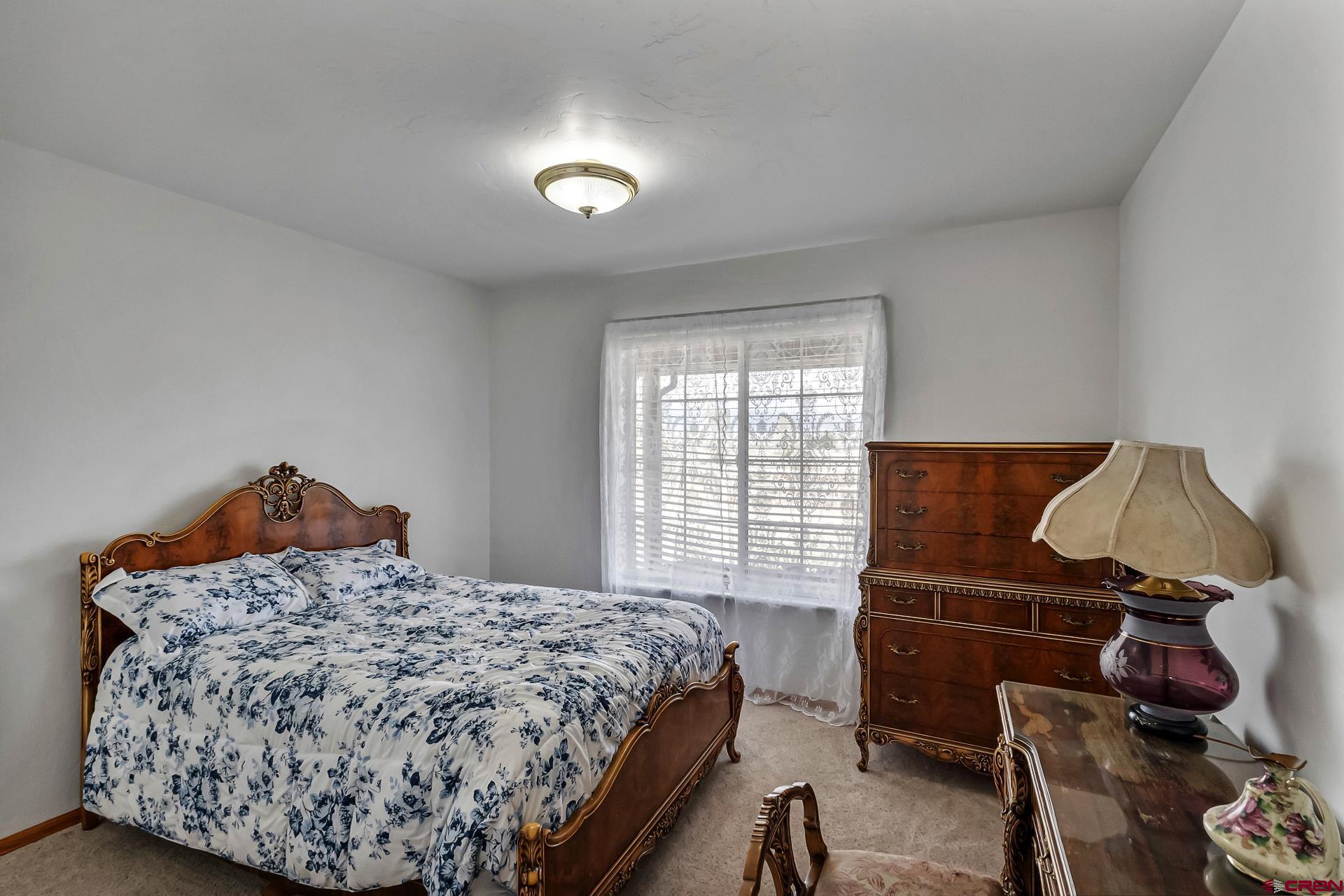 19632 E Road Delta, CO 81416 - Photo 20 of 45 a bedroom with a bed and dresser with wooden floor