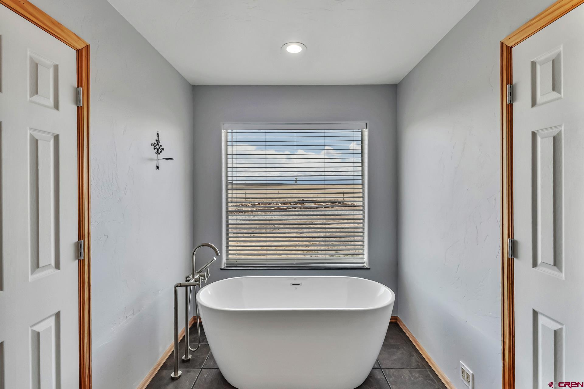 19632 E Road Delta, CO 81416 - Photo 30 of 45 a bathroom with a bathtub and a window