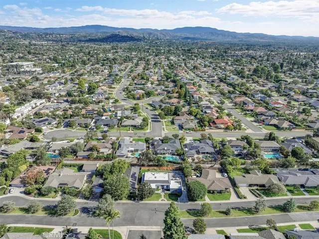an aerial view of residential houses with outdoor space and trees