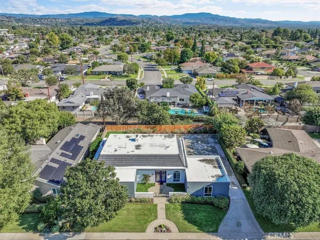 an aerial view of residential houses with outdoor space and parking
