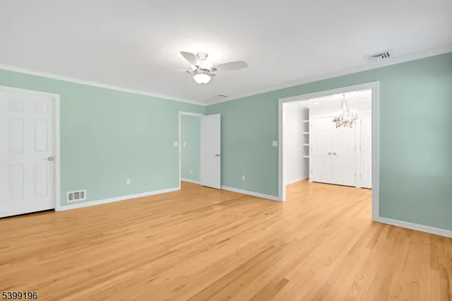 a view of empty room with window and ceiling fan