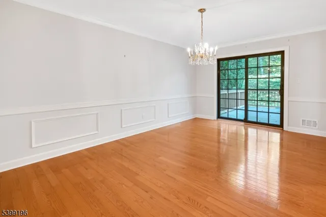 a view of empty room with wooden floor and fireplace