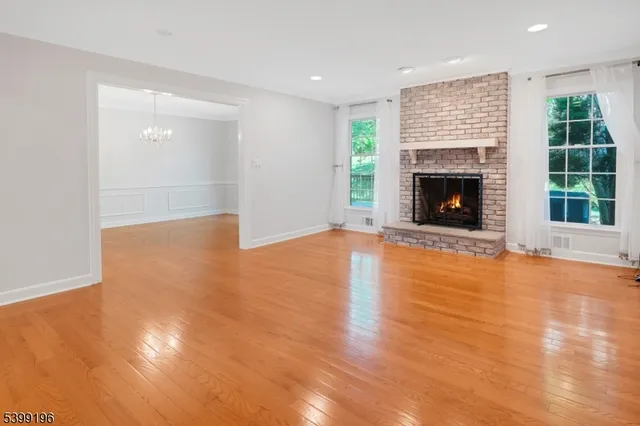 a view of an empty room with window and fireplace