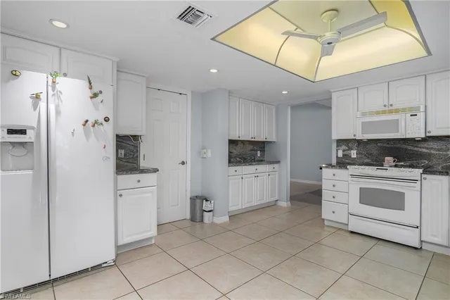 a kitchen with white cabinets and white appliances