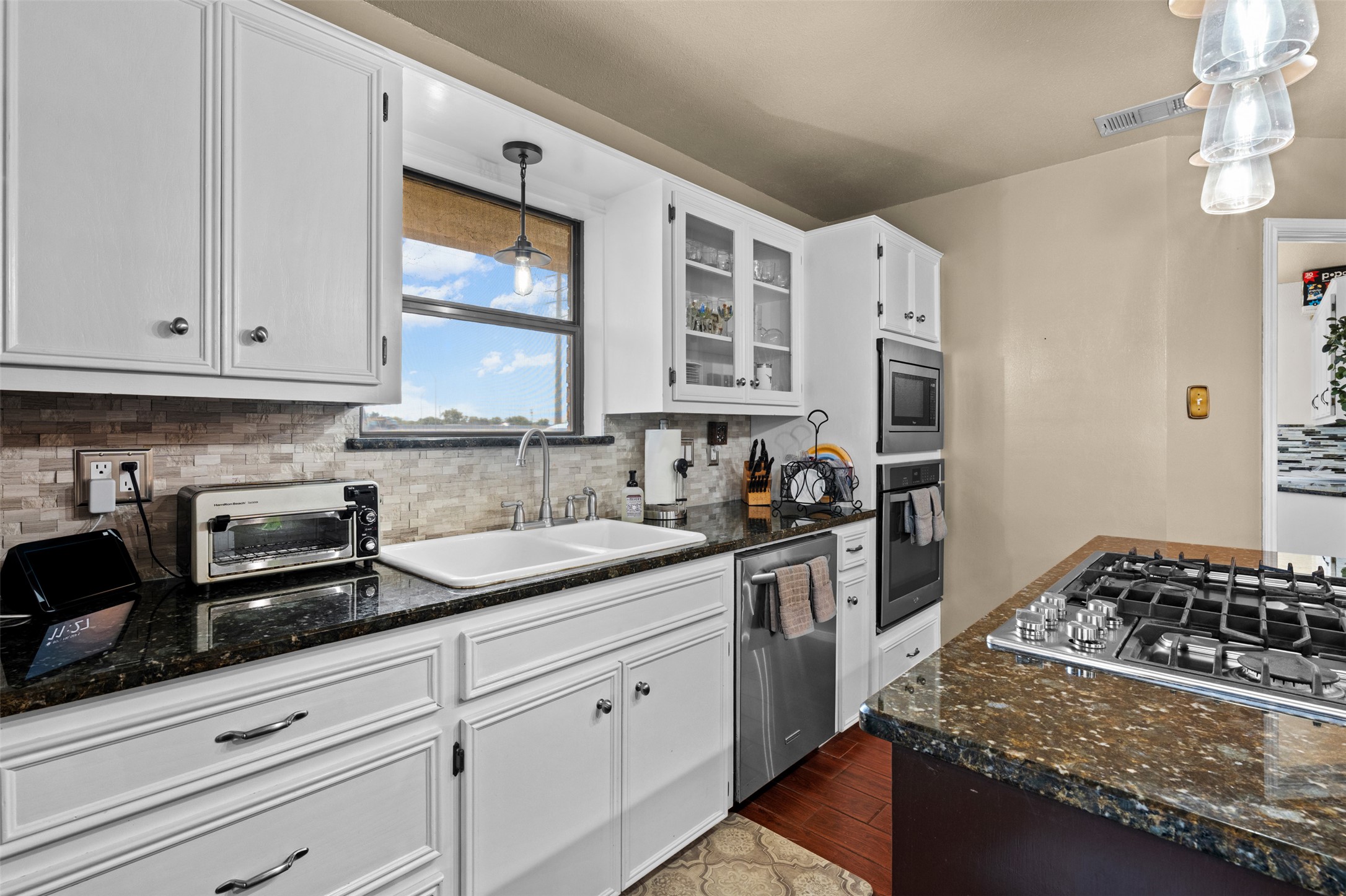 1512 Panther Loop Pflugerville, TX 78660 - Photo 25 of 40 White cabinetry with sleek hardware and dark granite counters define this inviting kitchen space.