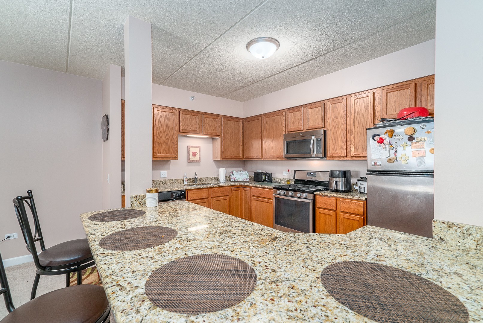 77 North Wolf Road, Unit 507 Northlake, IL 60164 - Photo 2 of 15 a kitchen with stainless steel appliances kitchen island granite countertop a sink and a refrigerator