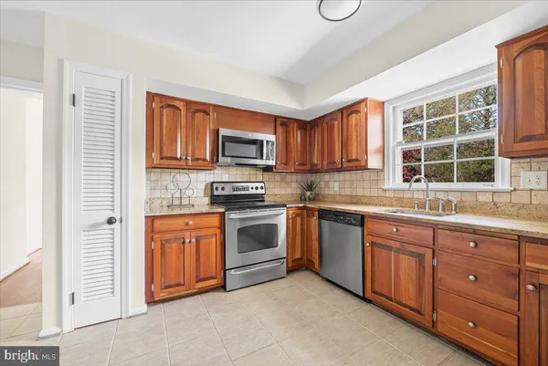 a kitchen with stainless steel appliances granite countertop a stove sink and microwave